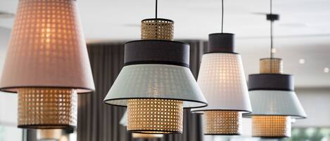 A row of pendant lights with a textured pattern, hanging from a ceiling in a modern interior setting.