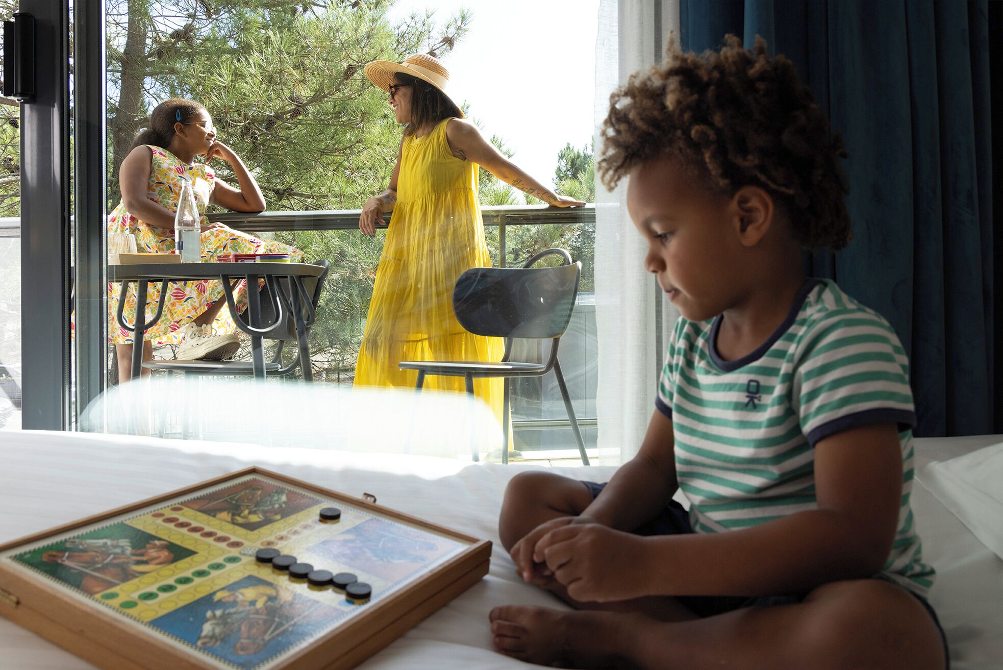 A child playing with a board game on a bed.