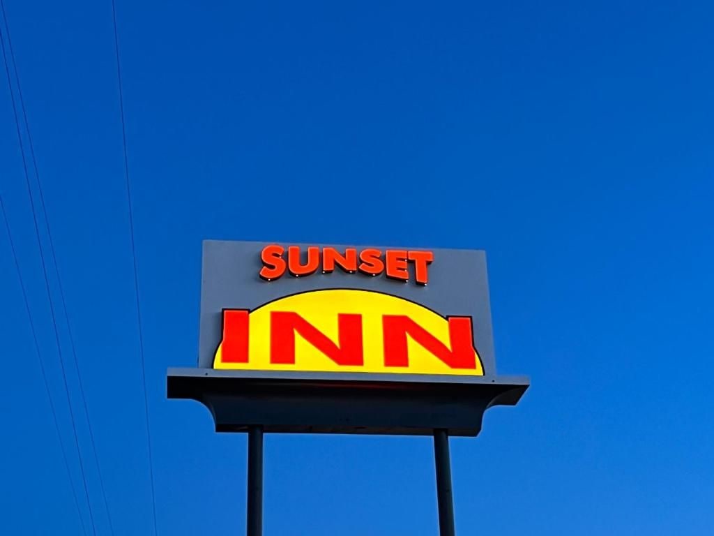 A clear view of a Sunset Inn sign against a blue sky.