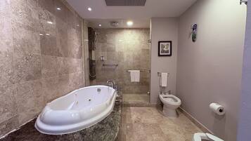 Une salle de bain comprenant une baignoire sur pieds, des toilettes, un bidet et un espace douche.