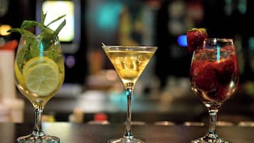 Drei Cocktails auf einer Bar, unscharfer Hintergrund.