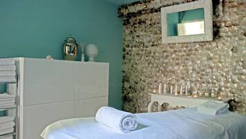 Relax in a serene space with a neatly made bed, a stylish wardrobe, and a soothing shell-patterned wall.