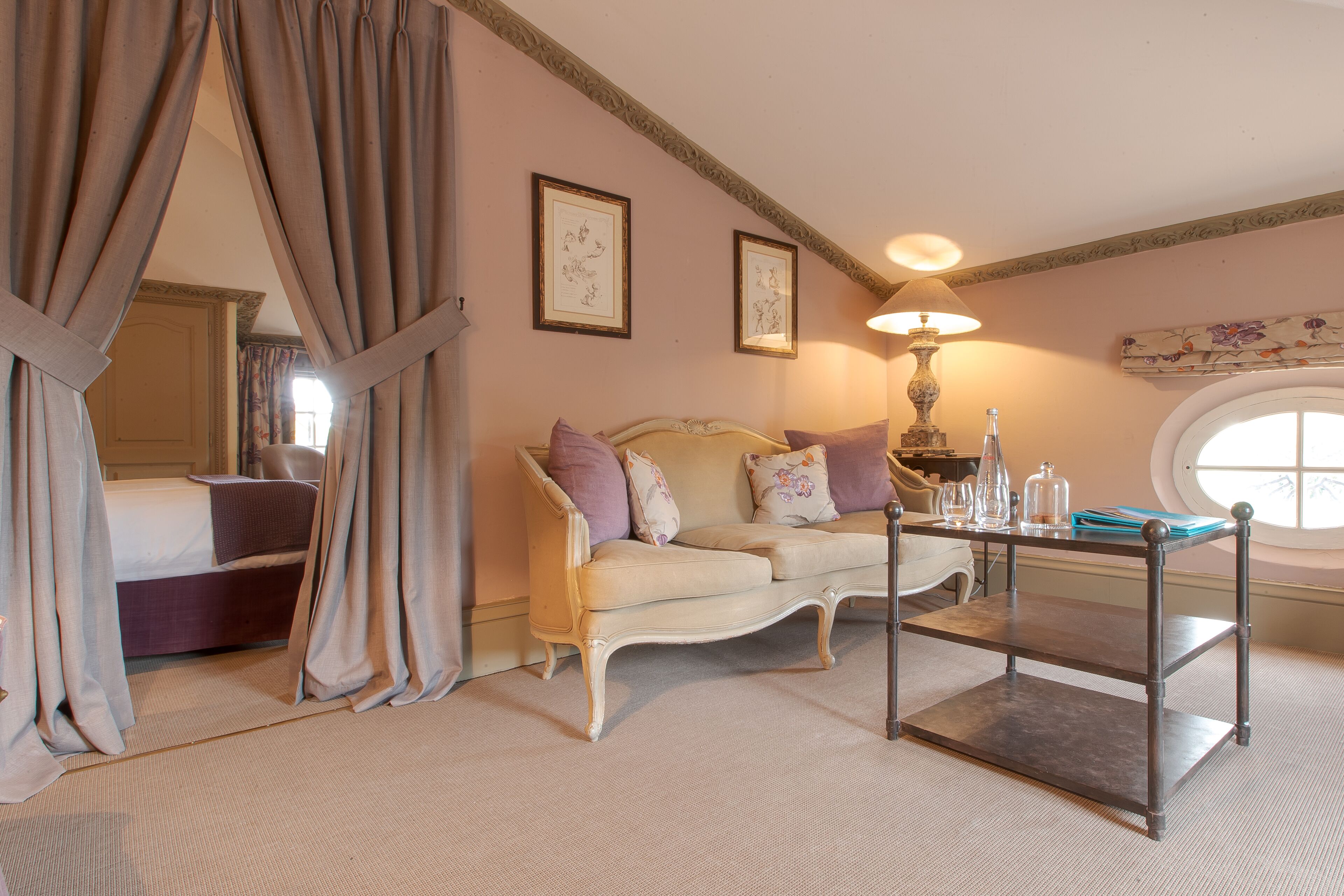 Une chambre à coucher avec un lit, un canapé, une table et une fenêtre.
