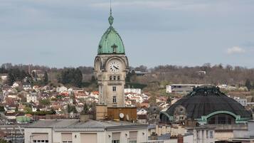 Una torre del reloj con una cúpula verde y un edificio más pequeño que también tiene un reloj.