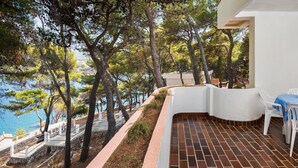 A terrace with a brick floor, white chairs, and a table with a blue tablecloth. - Resort Fontana (Jelsa)