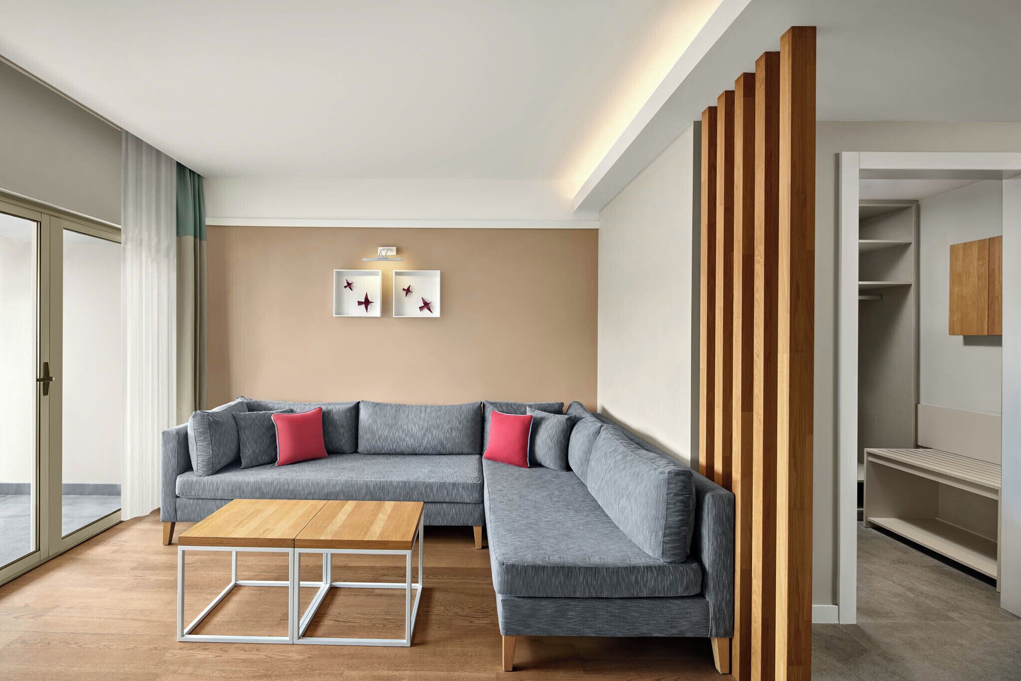 Una sala de estar moderna con un sofá modular, una mesa de centro de madera y una lámpara de techo.
