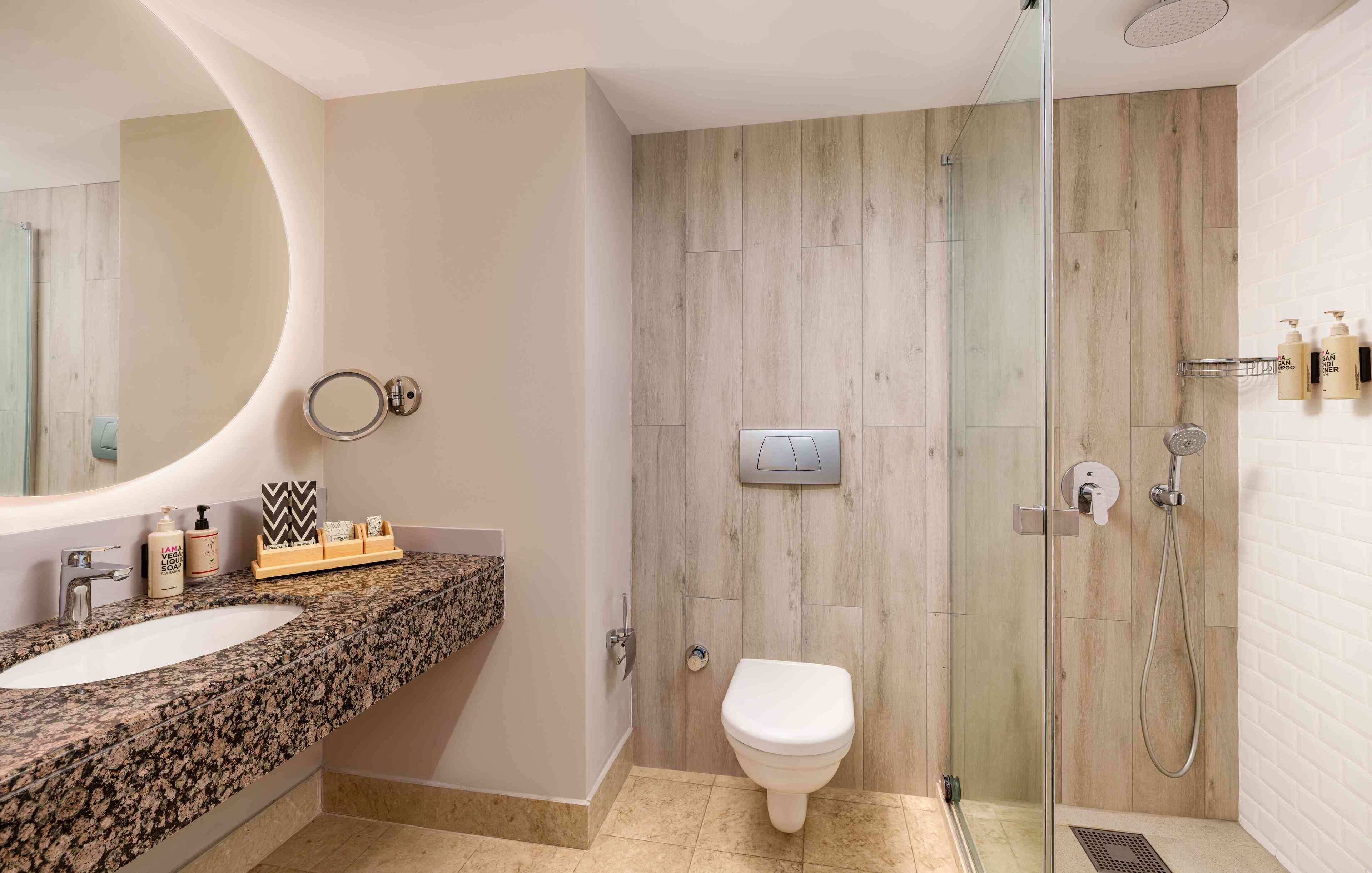 A bathroom with two sinks, a toilet, and a glass-enclosed shower.