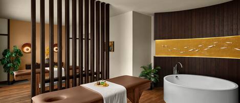 A modern bathroom with a wooden bench, a large bathtub, and a decorative wall piece.