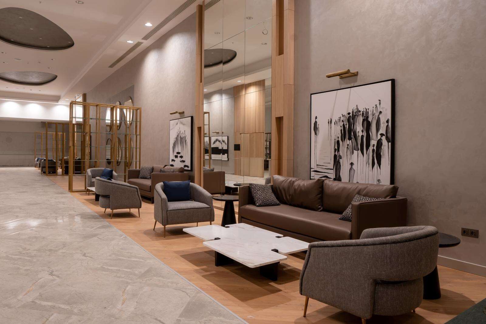 A modern lounge area with sofas, armchairs, and a coffee table.