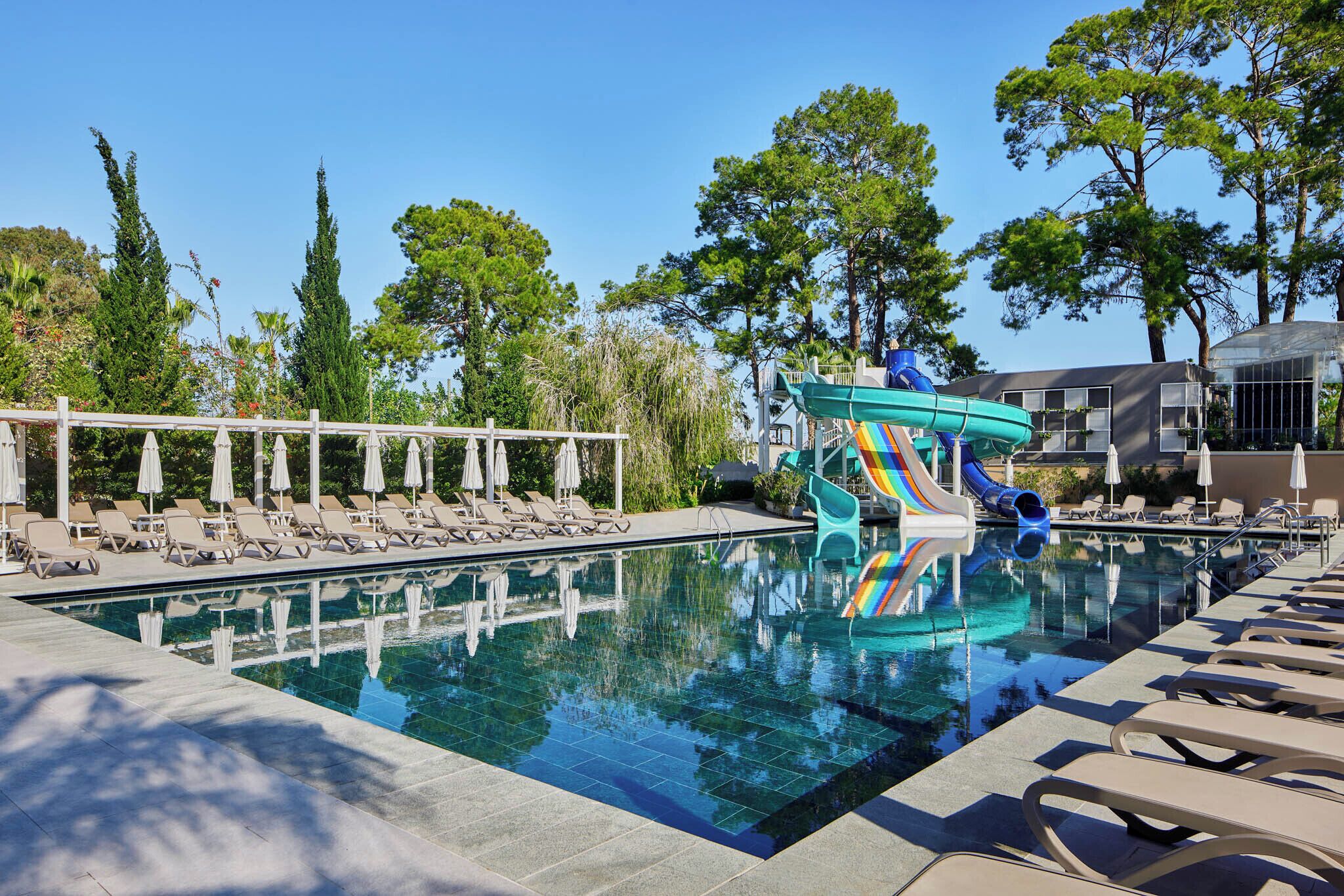 Una piscina cubierta, una piscina al aire libre de temporada, sombrillas