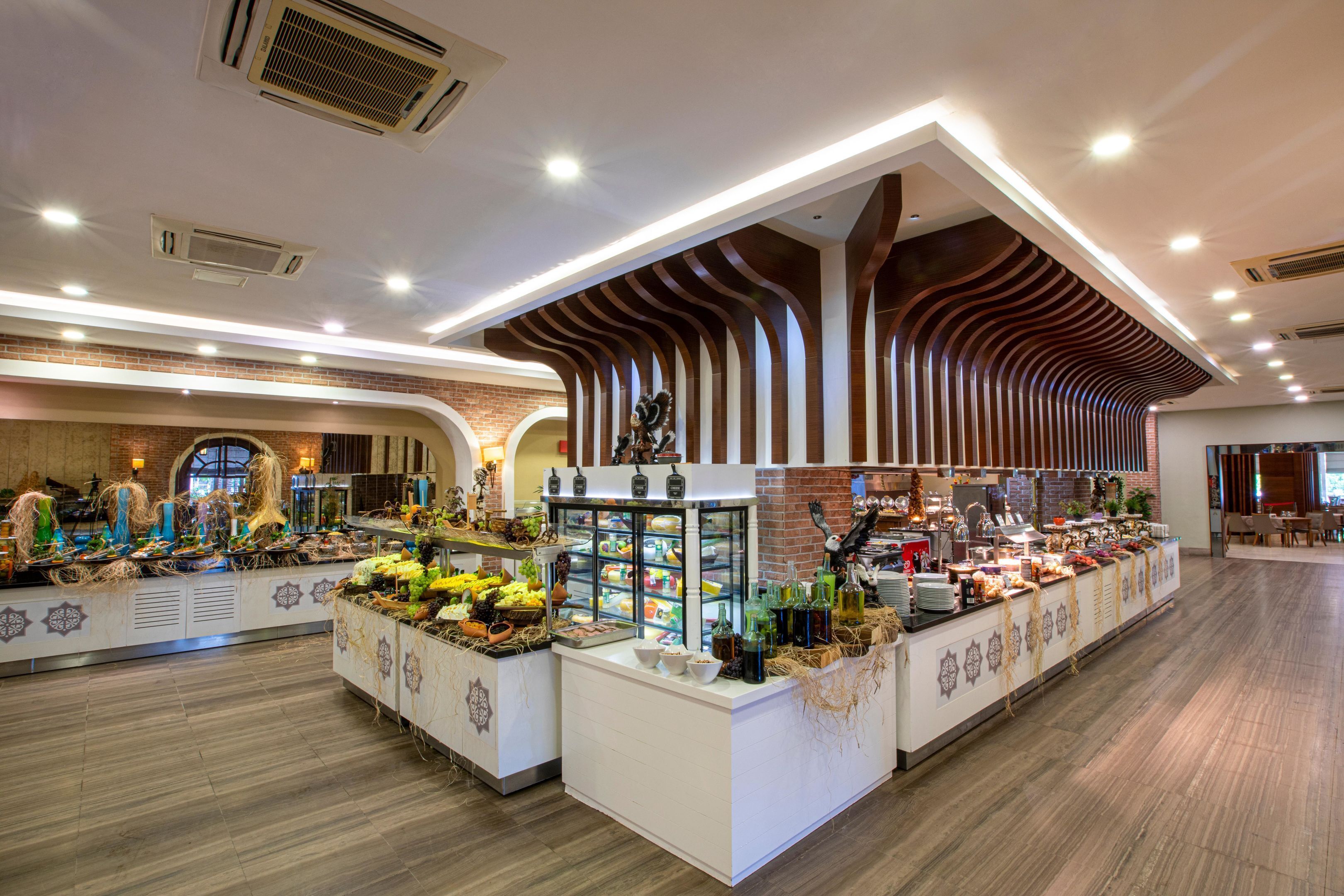 Een buffetgedeelte met verschillende stations, een centraal display en een met moderne vormgeving beklede bakstenen muur.