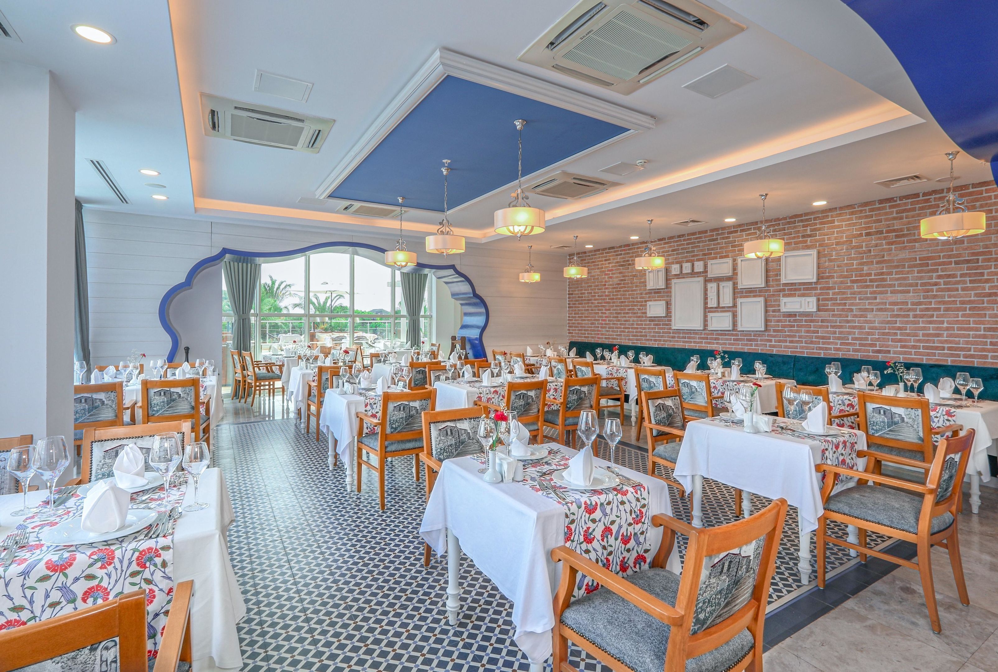 Un restaurant doté de nombreuses tables, de chaises et d’un sol à motifs.