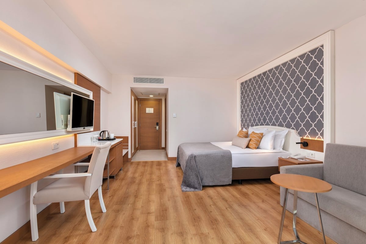 Habitación Deluxe, vistas parciales al mar | Ropa de cama de alta calidad y minibar con artículos gratuitos
