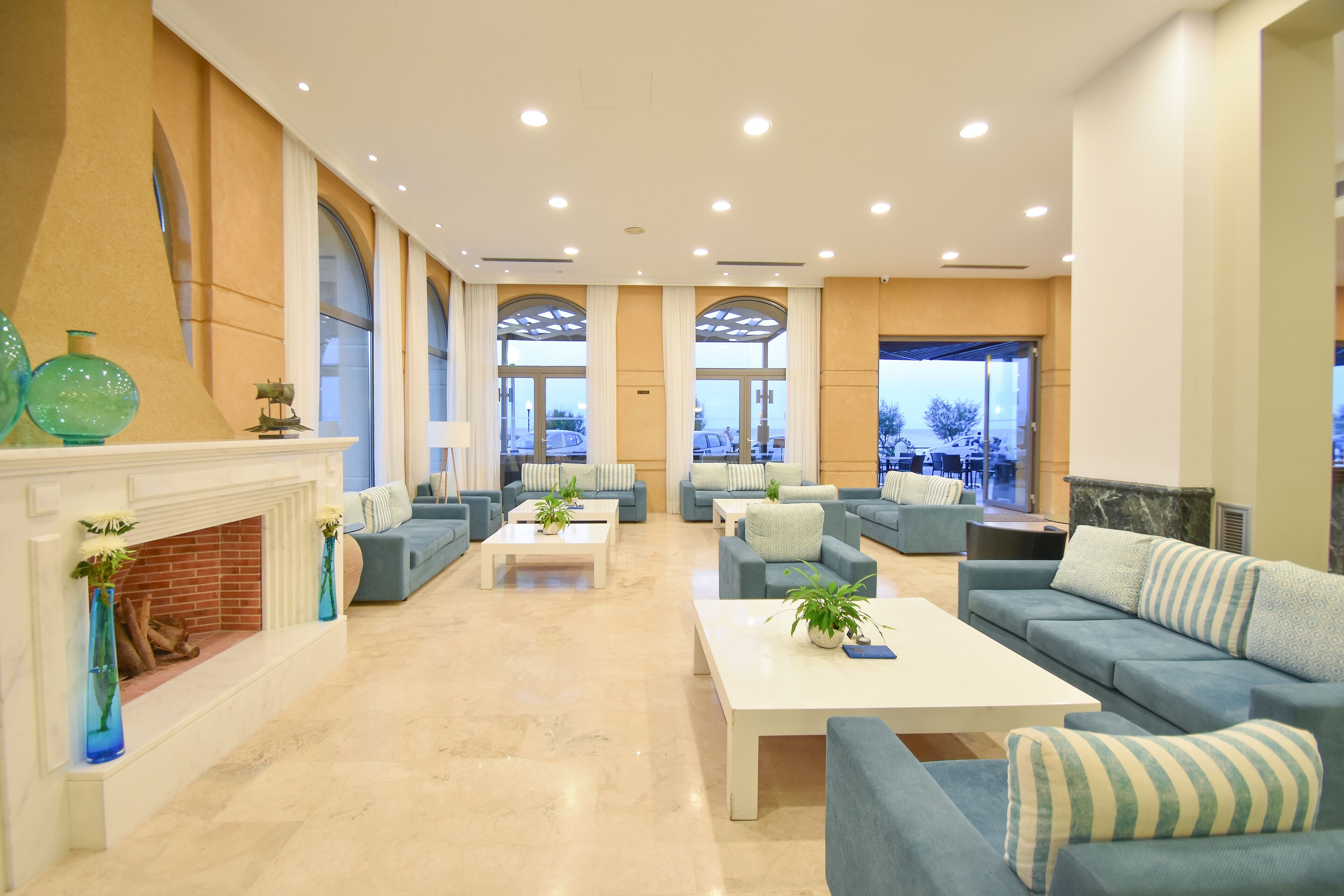 A spacious lobby with a fireplace, sofas, and a coffee table.