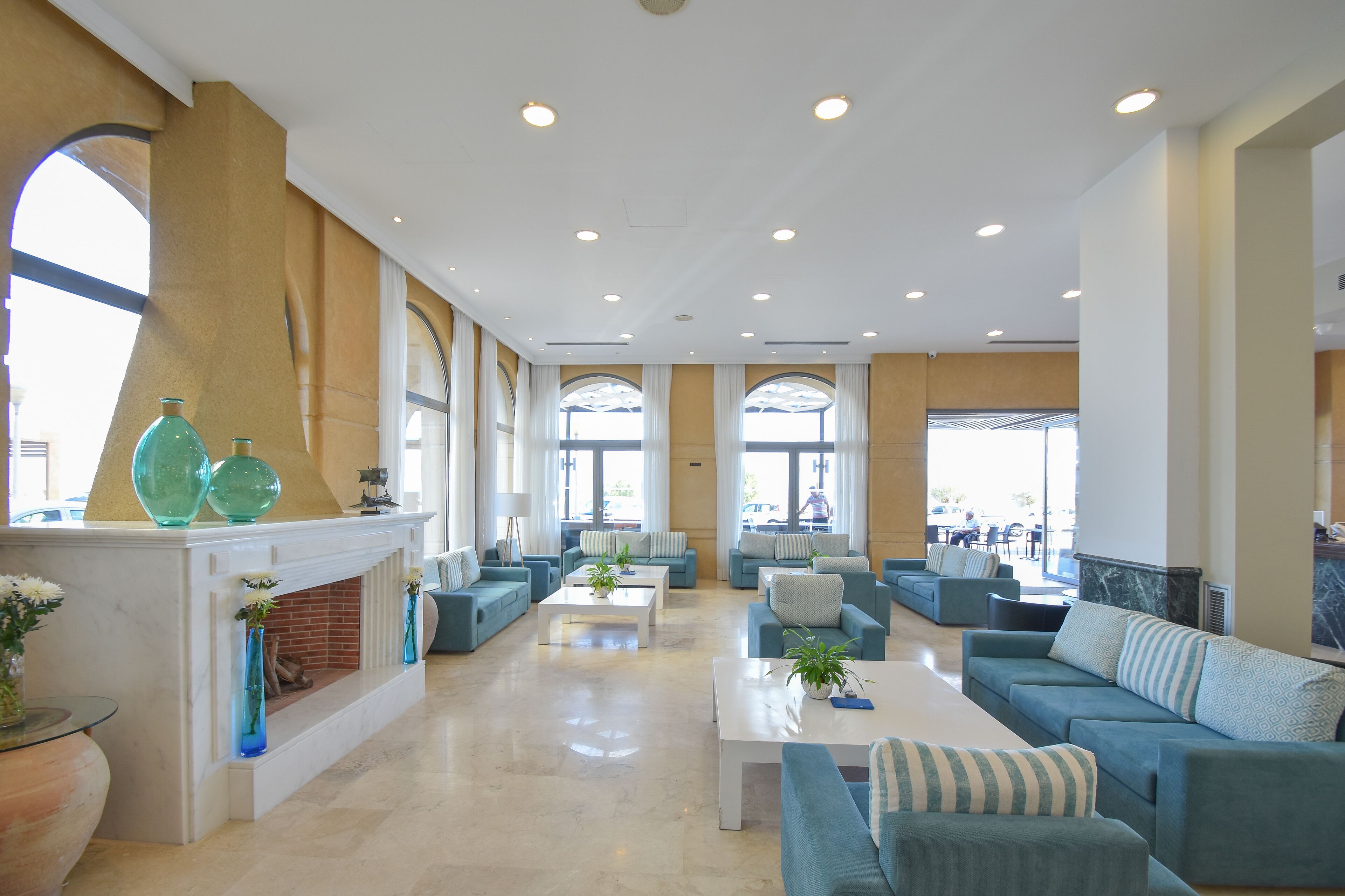 A spacious lobby with a fireplace, comfortable seating, and large windows.