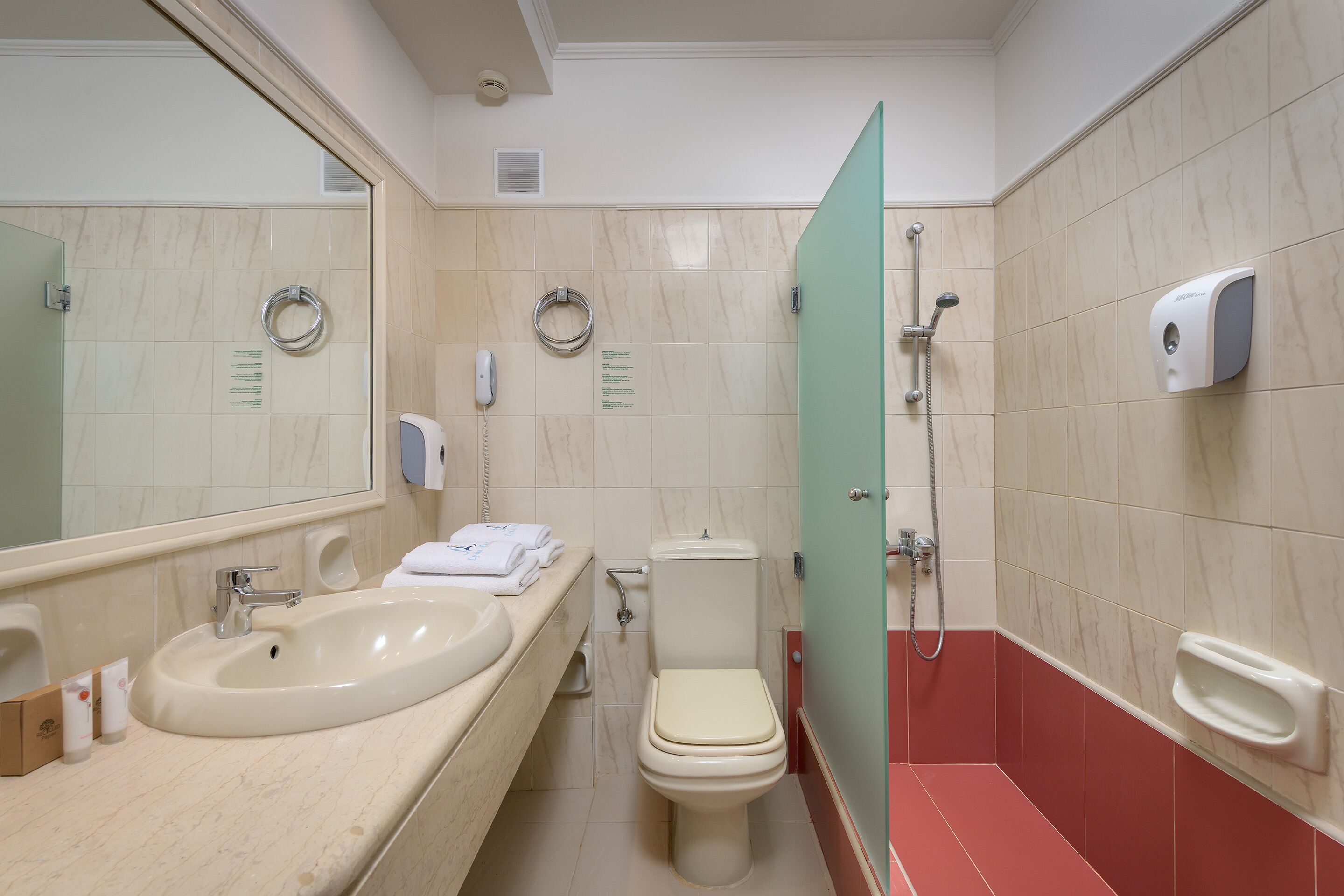 A bathroom with a sink, toilet, and shower.