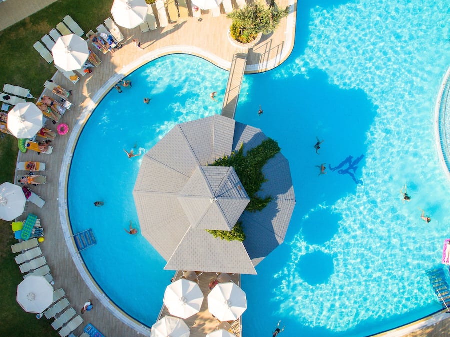 Una piscina al aire libre, una piscina con borde infinito, sombrillas