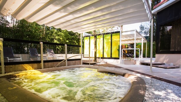 A hot tub area with a covered seating area and a view of the surrounding greenery. - Grand Hotel Panoramic (Montecatini Terme)