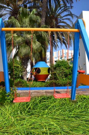 A playground with swings and a colorful ball pit.
