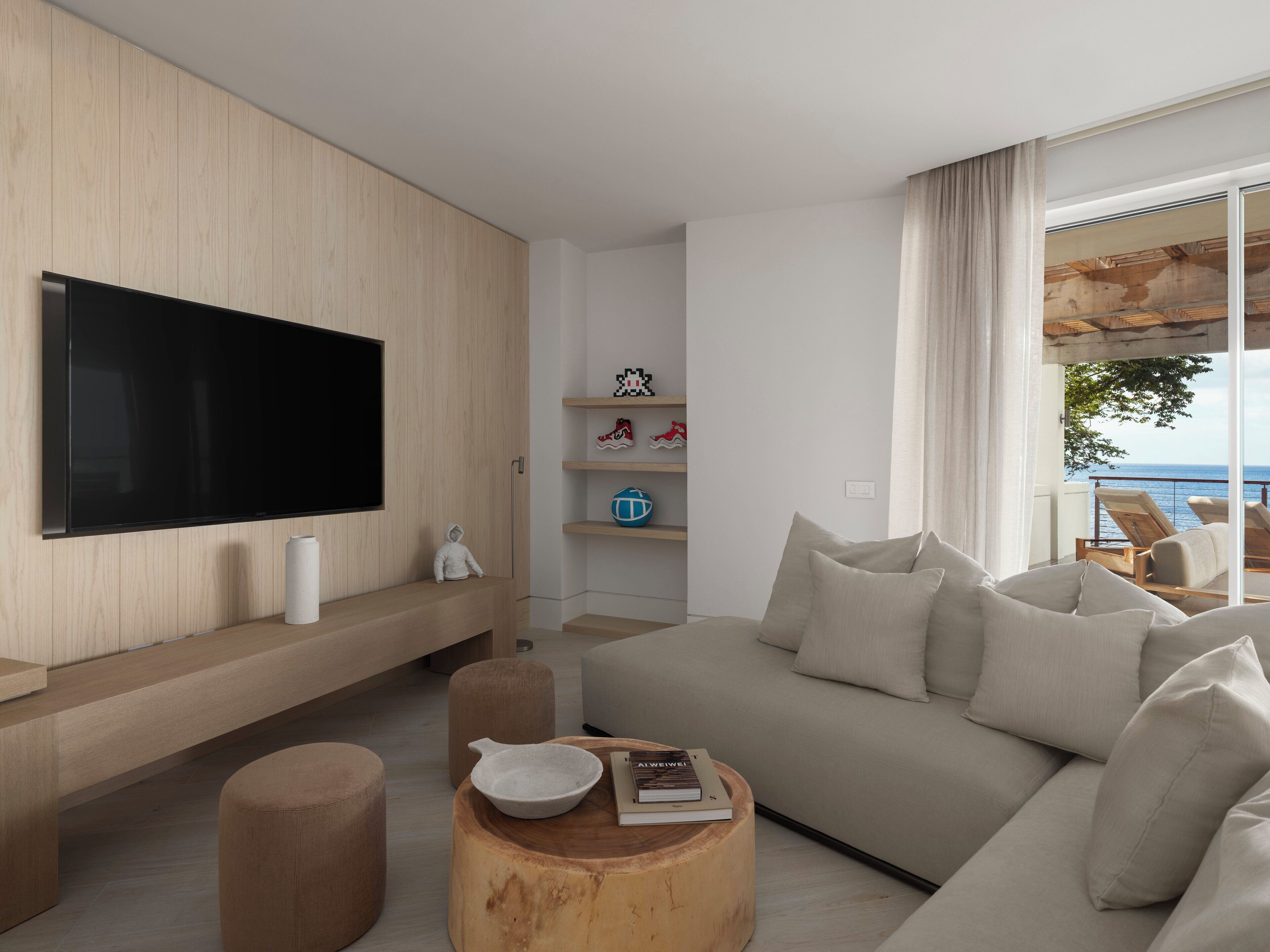 Una sala de estar moderna con un televisor de pantalla plana grande, un sofá y una mesa de centro.