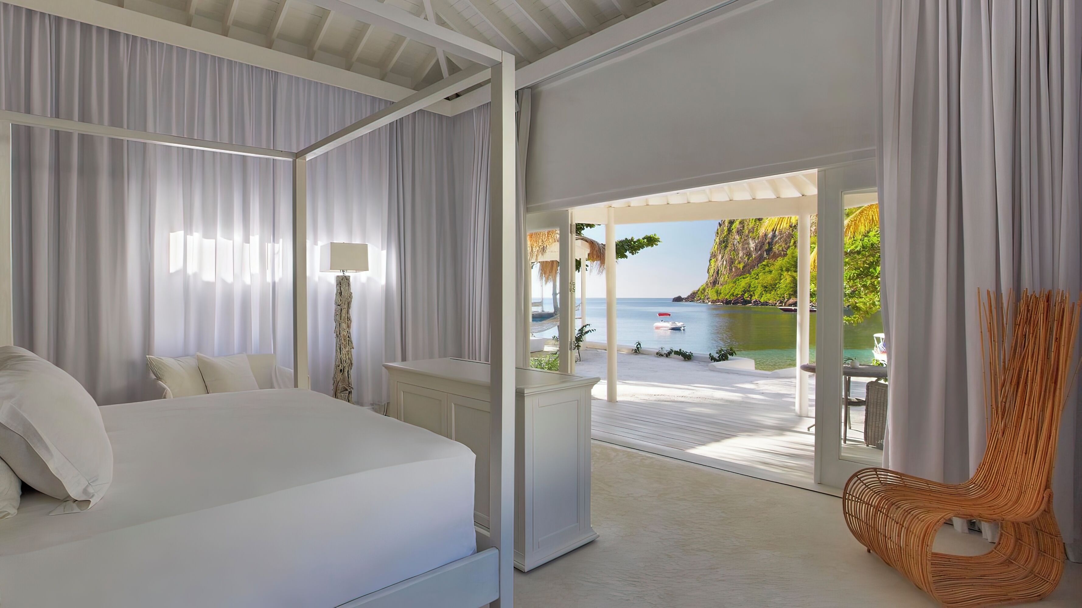 Habitación de hotel con cama, escritorio y vista a la playa.