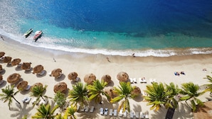 An aerial view of a beach with thatched umbrellas, palm trees, and sun loungers. - Sugar Beach, A Viceroy Resort (Soufrière)