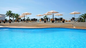 A pool area with lounge chairs and umbrellas, surrounded by palm trees. - Nerja Club by Dorobe (Nerja)