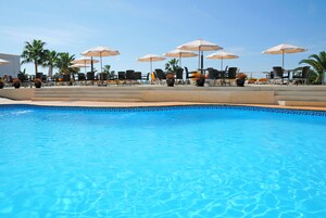 Una piscina al aire libre, tumbonas