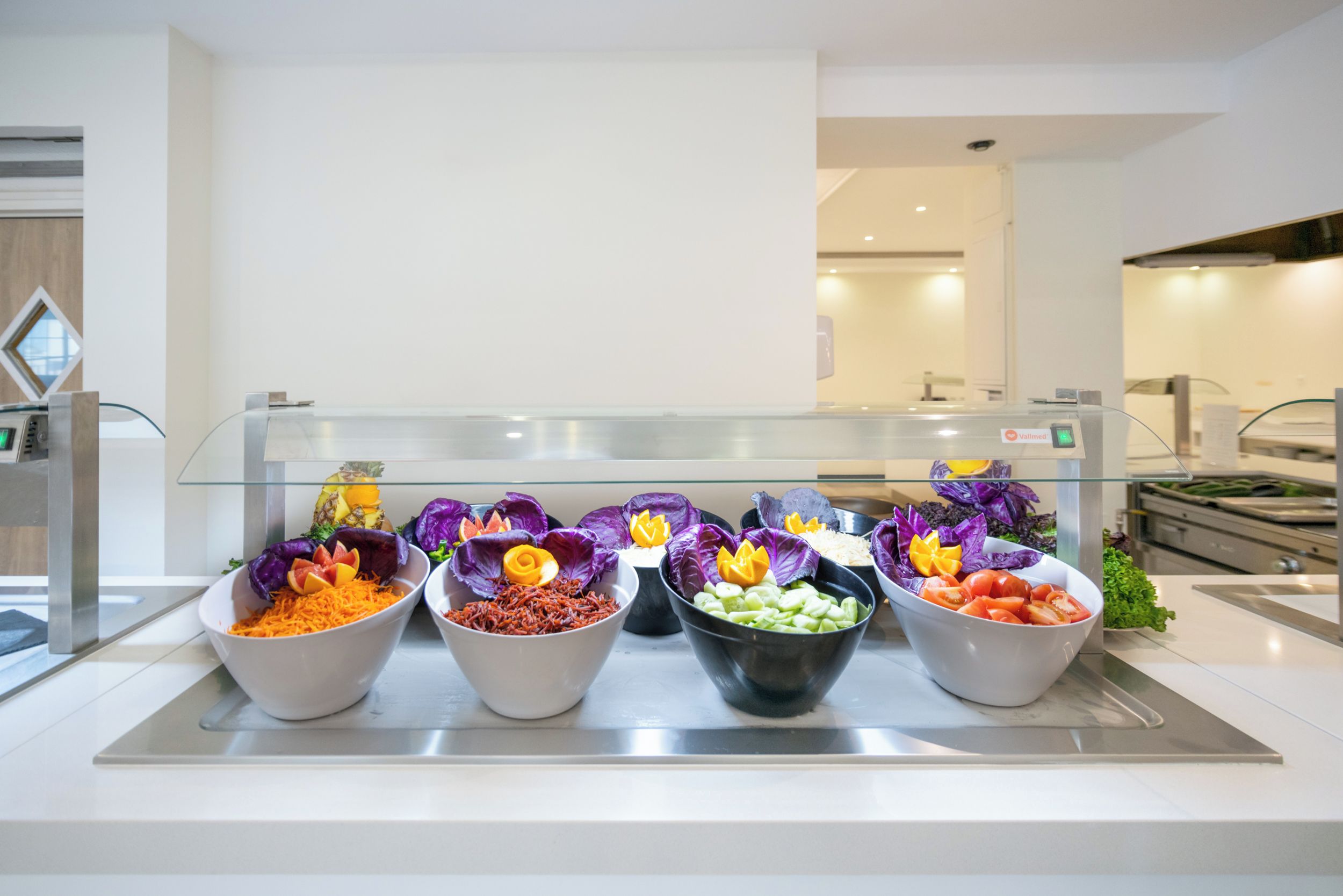 Un buffet garni de différents plats présentés dans des récipients et agrémenté de fleurs décoratives.