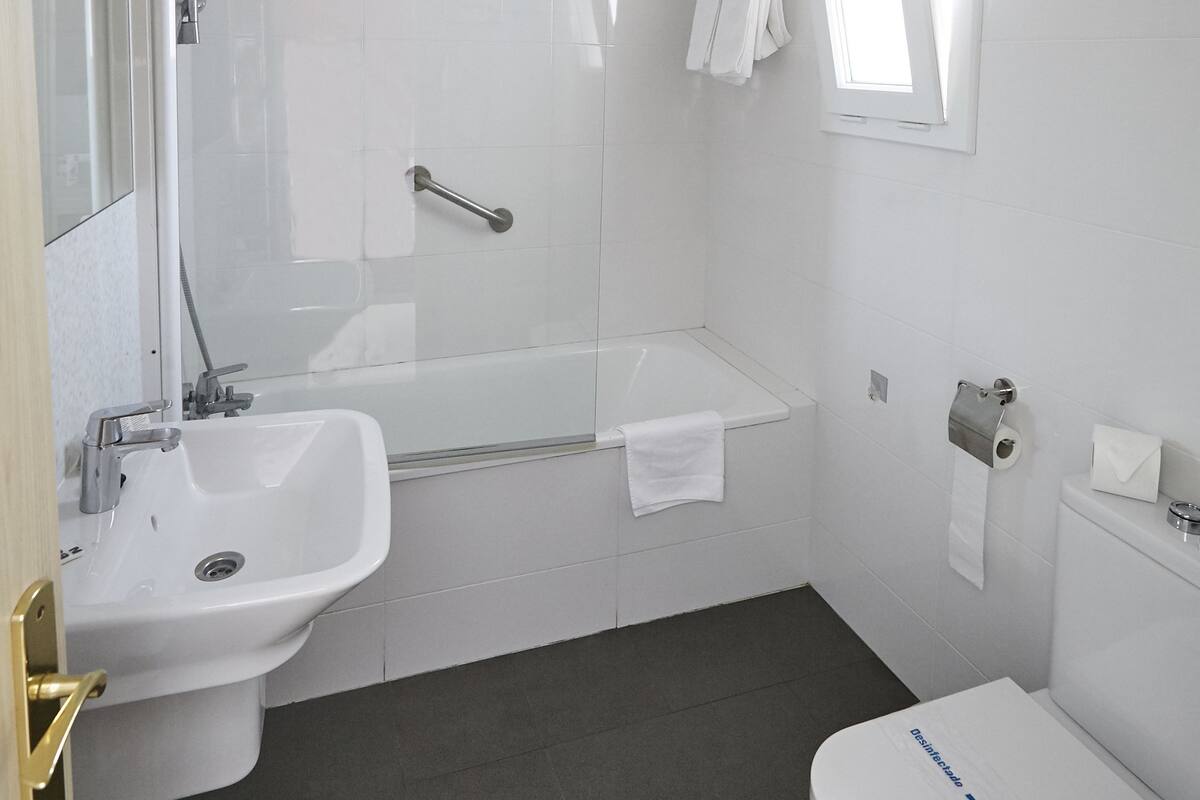 Un baño moderno con bañera, lavamanos e inodoro.