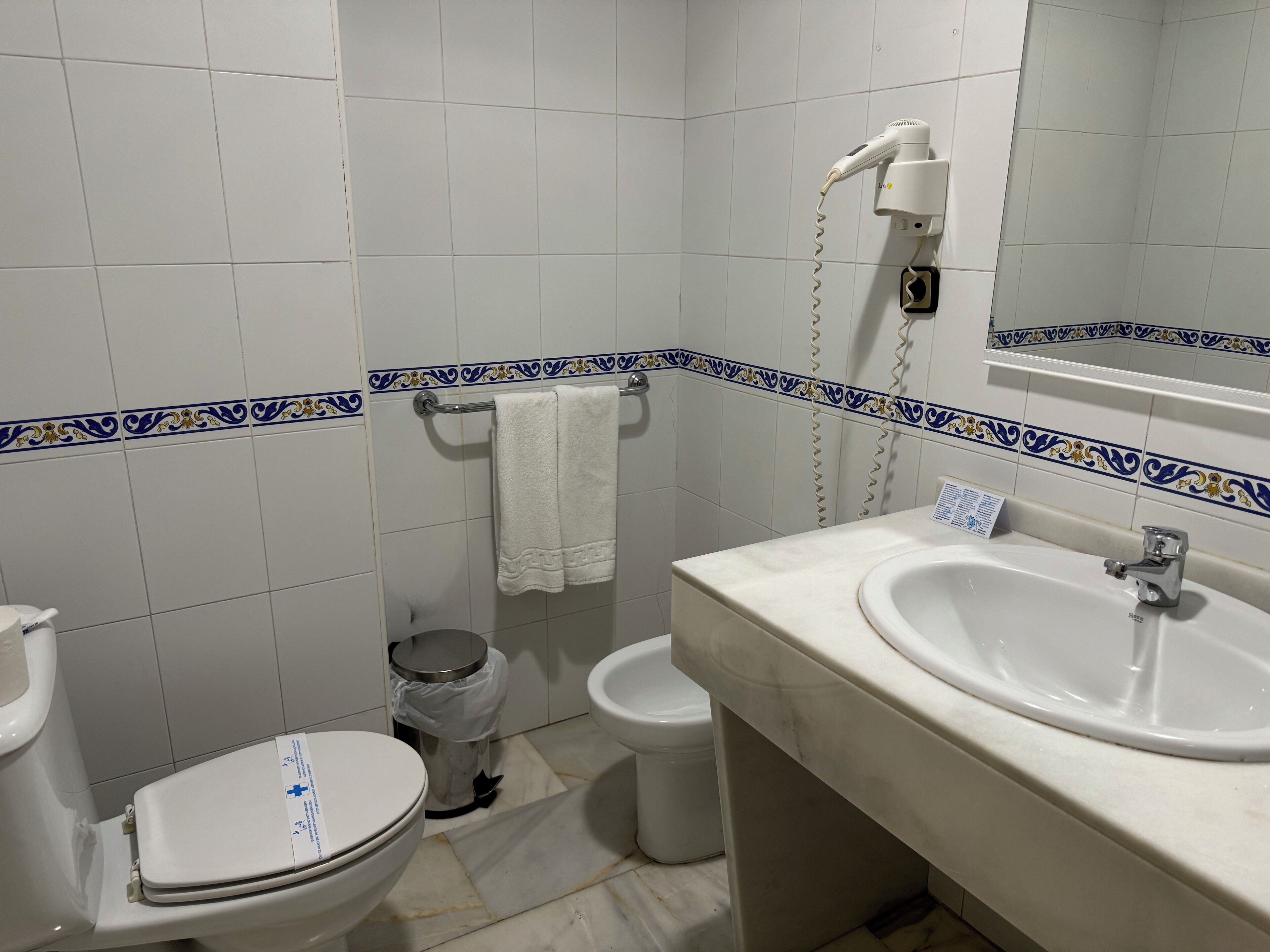 A bathroom with a toilet, bidet, and sink.