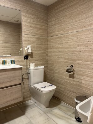 Economy tweepersoonskamer (Free Spa) | Badkamer | Een bad/douchecombinatie, gratis toiletartikelen, een haardroger