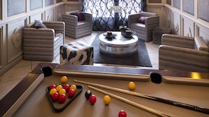 A billiards table with balls and cues, a pool table, and two sofas with cushions. - Residence Village Montana (Les Belleville)