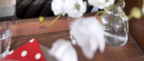 A neatly made bed with white and red pillows, a wooden headboard, and a framed picture above.