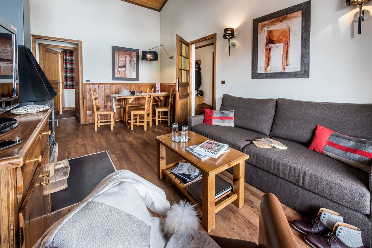 Un salon chaleureux avec un canapé, une table basse et un coin repas doté de meubles en bois.