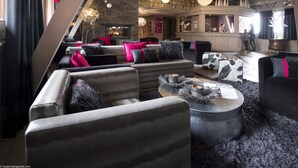 A modern interior with a fireplace, leather sofas, and a bar area. - Residence Village Montana (Les Belleville)