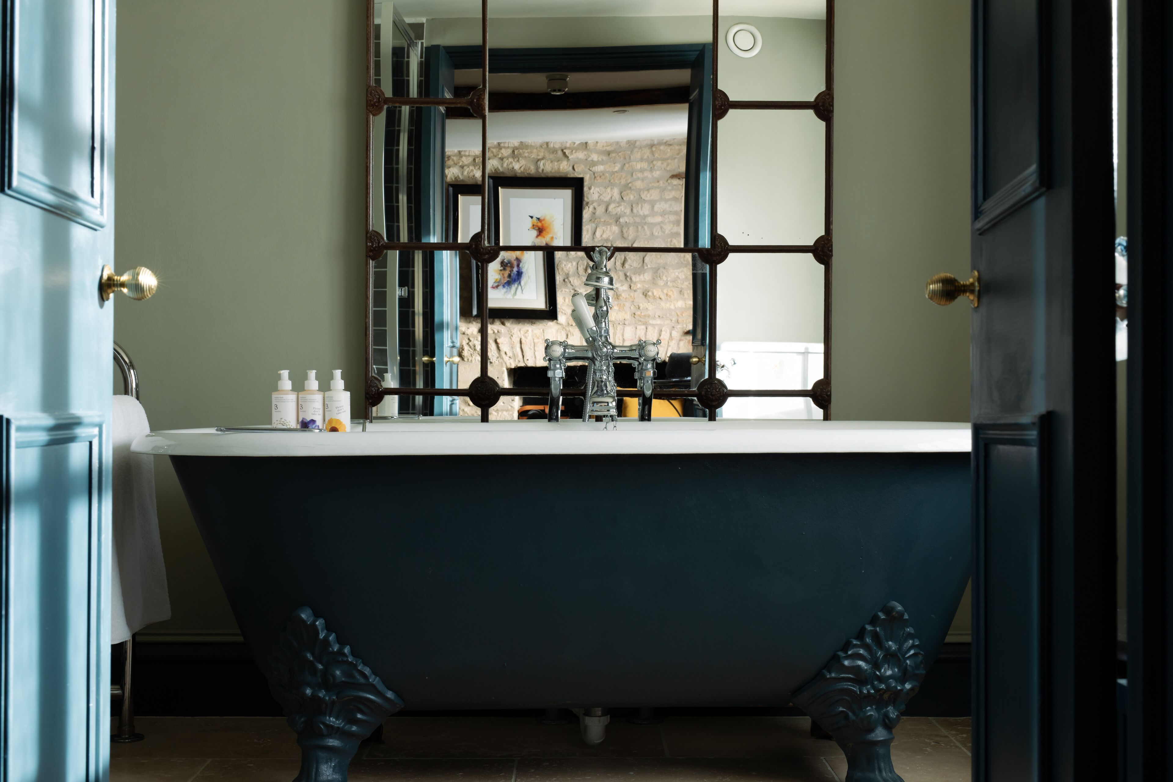 Ein Badezimmer mit einer freistehenden Badewanne, einem Spiegel und einem Waschbecken.