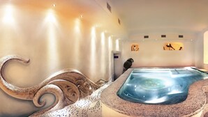 A spa area with a hot tub, a stone bench, and a shower area.