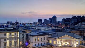 A cityscape at dusk with a prominent building featuring a clock tower and classical architecture.