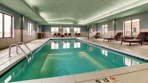 An indoor swimming pool with clear water, a diving board, and lounge chairs. - Holiday Inn Express & Suites Montpelier by IHG (Montpelier)