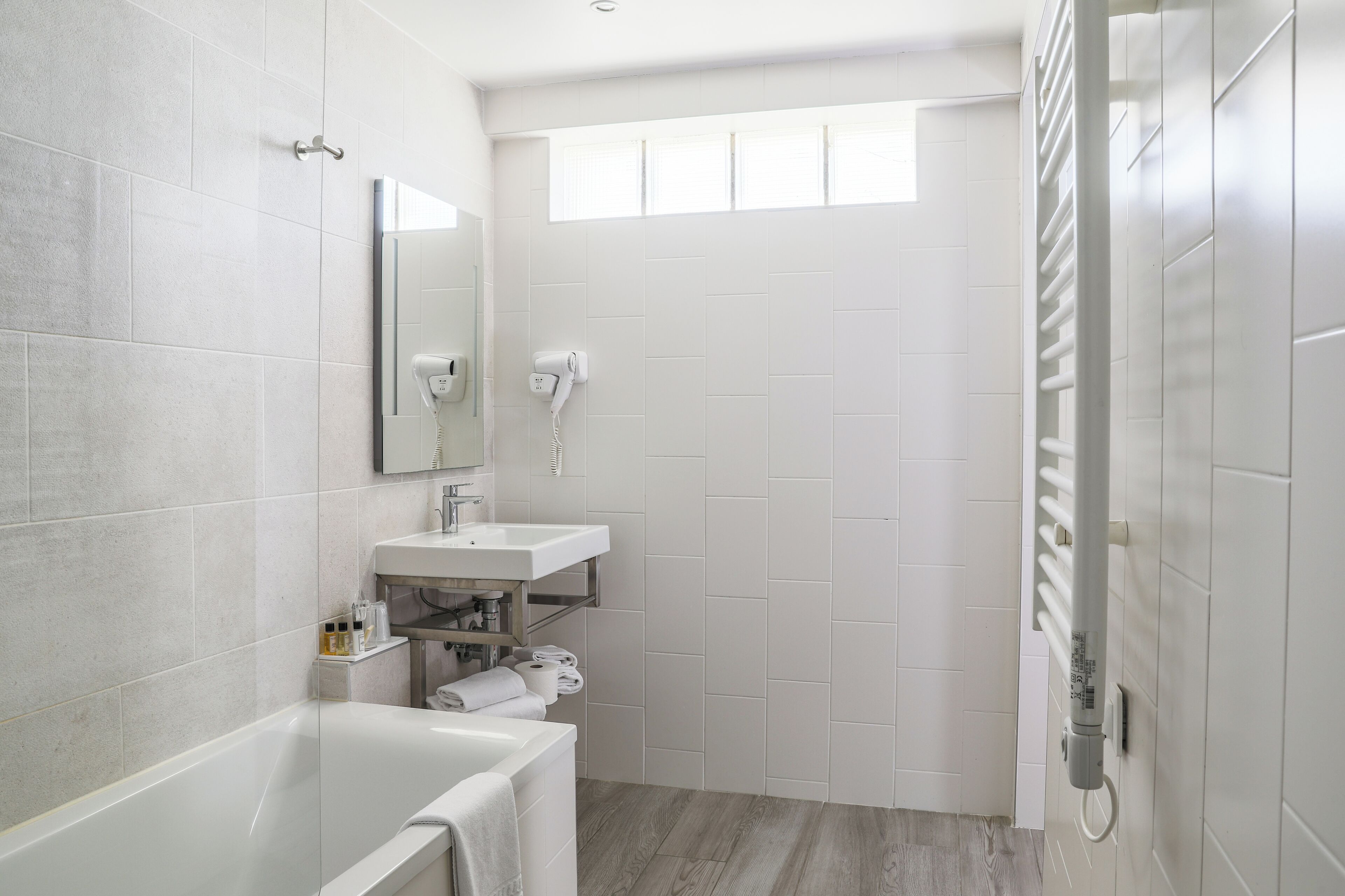 Een moderne badkamer met een bad, een wastafel en een douche.