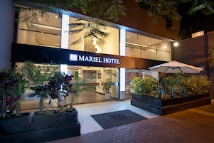 Exterior del Hotel Mariel, con un diseño moderno, ventanas amplias y un jardín bien cuidado.