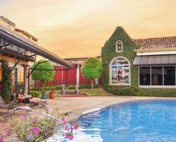 Una piscina al aire libre, sillones reclinables de piscina