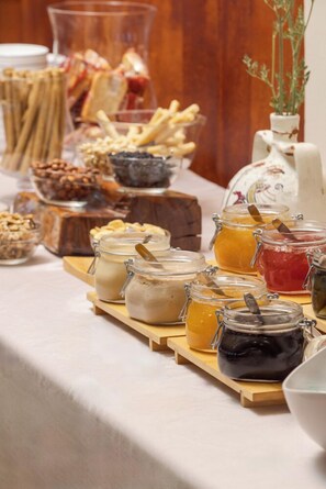 A buffet table with various food items and condiments.