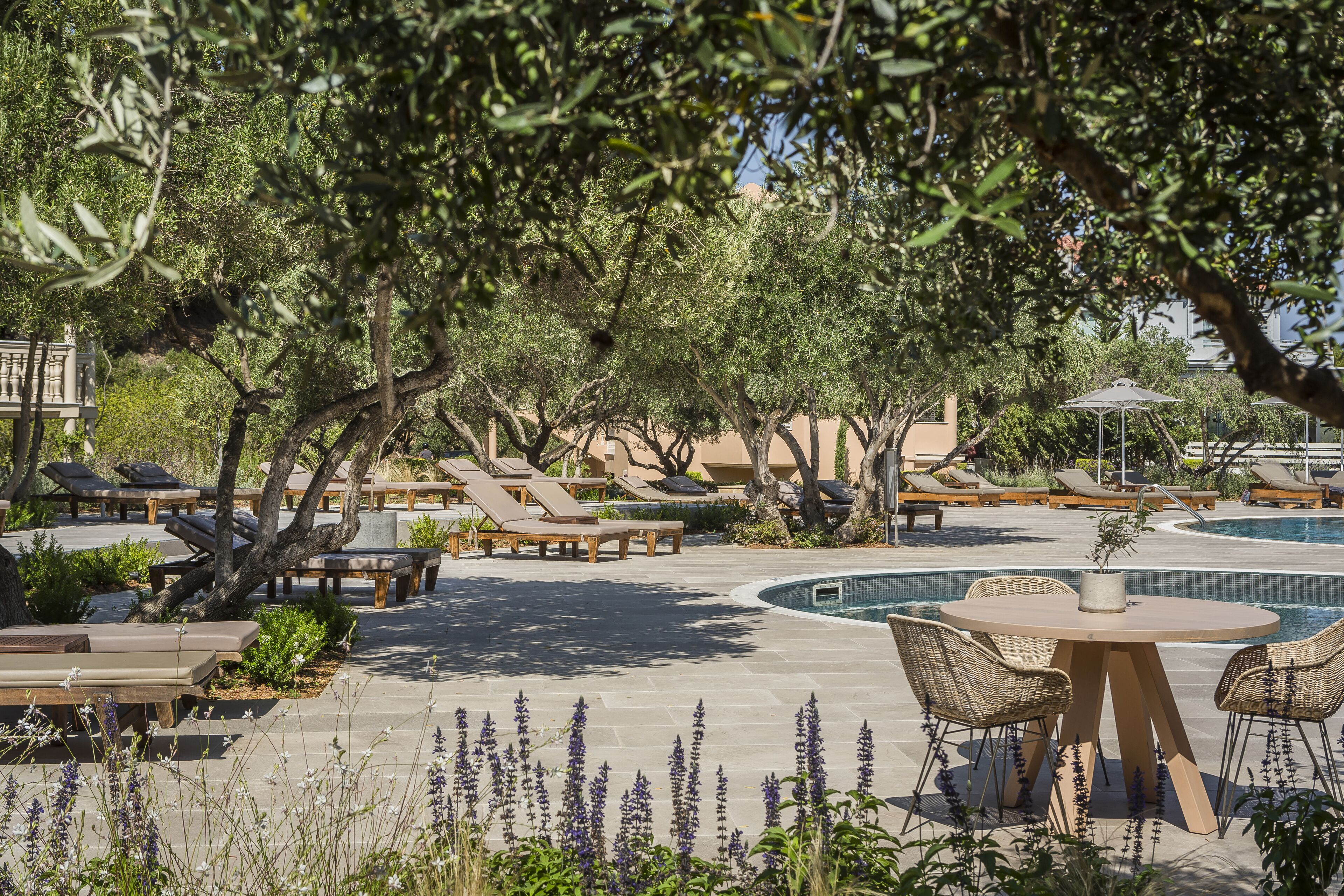 A poolside area with lounge chairs, a round table, and a small pool.
