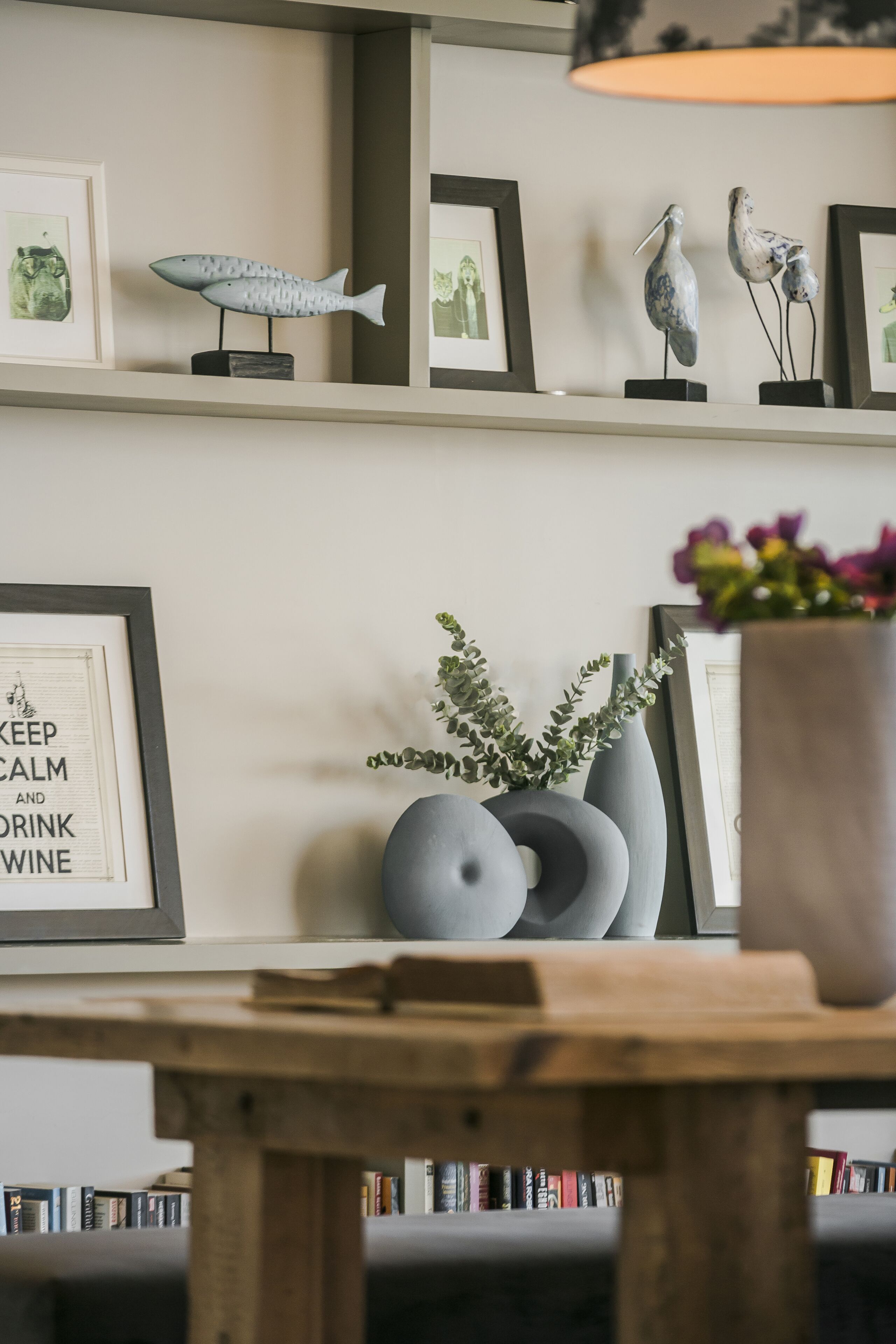 A bookshelf with books, a framed quote, and decorative items on a shelf.