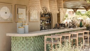 A bar area with a green tiled backsplash, wooden bar stools, and hanging wicker lamps. - Thalassa Boutique Hotel - Adults Only (Kefalonia)