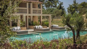 A poolside area with multiple lounge chairs and a pool. - Thalassa Boutique Hotel - Adults Only (Kefalonia)