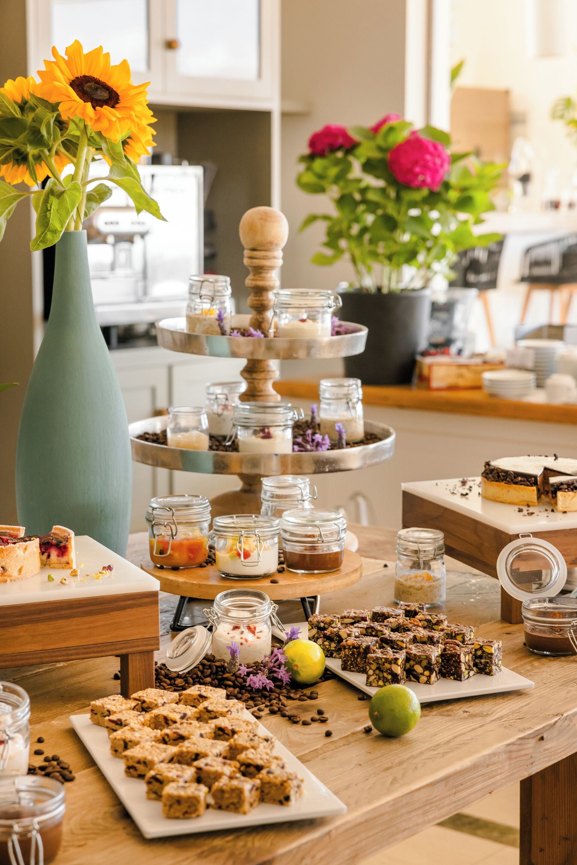 A dessert table with various sweets and a tiered serving stand.