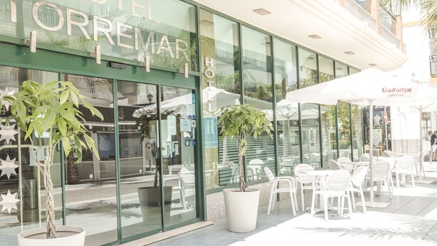Un hôtel doté d’une terrasse et de grandes fenêtres.